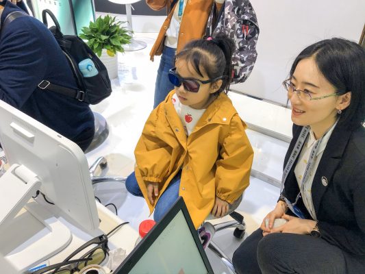 Yolanda LI, APAC Optometry Education Manager is helping a 5-year old girl to experience Eyeviz300.